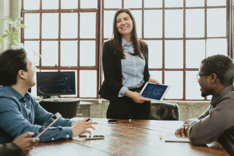 happy businesspeople in a meeting using a tablet mockup